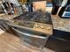 Stainless steel range oven with granite countertops, cabinet storage, and modern appliances at 7068 Parrot Bay Way, Las Vegas, NV 89118