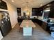 Spacious kitchen featuring dark cabinets, granite countertops, and a large center island at 7068 Parrot Bay Way, Las Vegas, NV 89118