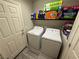 Laundry room featuring a washer, dryer, and shelving for storage at 7068 Parrot Bay Way, Las Vegas, NV 89118