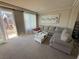 Open living room with a balcony, neutral carpet, and contemporary furnishings at 7068 Parrot Bay Way, Las Vegas, NV 89118