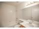 Bright bathroom with tub, shower, white tile, large mirror, and single sink at 8072 Big Top Dr, Las Vegas, NV 89123