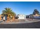Single-story home featuring a two-car garage, xeriscape landscaping, and mature palm trees at 8072 Big Top Dr, Las Vegas, NV 89123