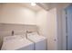 Convenient laundry room featuring a washer, a dryer, and a storage shelf at 8072 Big Top Dr, Las Vegas, NV 89123