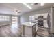 Open kitchen and living area with white cabinets, an island, stainless appliances, and a sliding door at 904 Melic Way, North Las Vegas, NV 89032