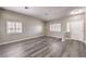 Bright and airy living room with grey wood flooring, white trim, and natural light from the window at 904 Melic Way, North Las Vegas, NV 89032