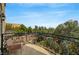 Charming balcony featuring decorative wrought iron railing with seating and tree top views at 9101 Alta Dr # 11, Las Vegas, NV 89145