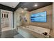 This primary bathroom features a glass enclosed shower, a separate soaking tub, and a wall mounted TV at 9101 Alta Dr # 11, Las Vegas, NV 89145