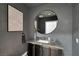 Stylish powder room with modern fixtures, grey walls, dark cabinets, and a round mirror at 9101 Alta Dr # 11, Las Vegas, NV 89145