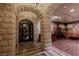 Stone foyer featuring arched doorway, mosaic tile floor, and decorative wrought iron doorway at 9101 Alta Dr # 11, Las Vegas, NV 89145