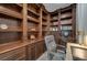 Home library complete with rich, dark wooden bookshelves, detailed molding, and comfortable chair at 9101 Alta Dr # 11, Las Vegas, NV 89145