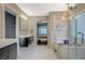 Beautiful primary bathroom with white tile floors, dual sinks, and a standalone soaking tub at 9601 Rolling Thunder Ave, Las Vegas, NV 89148