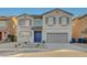 Two-story home featuring gray trim, a blue front door, and a two-car garage at 9601 Rolling Thunder Ave, Las Vegas, NV 89148