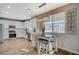 Bright kitchen with stainless steel appliances, white cabinetry, eat-in breakfast table, and stylish light fixture at 9601 Rolling Thunder Ave, Las Vegas, NV 89148