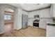 Spacious kitchen featuring stainless appliances, white cabinetry, stylish backsplash and hardwood floors at 9601 Rolling Thunder Ave, Las Vegas, NV 89148