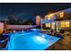 Beautiful backyard pool and spa illuminated at night with a nearby upper balcony and lounge chairs offer a relaxing outdoor space at 9601 Rolling Thunder Ave, Las Vegas, NV 89148