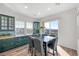 A sunlit dining area with a dining table, six chairs, modern cabinets, and a sliding glass door to the yard at 1 Vicolo Bella, Henderson, NV 89011