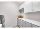 Laundry room with white cabinets, gray counters, and modern washer and dryer at 1 Vicolo Bella, Henderson, NV 89011