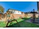 Spacious backyard featuring artificial turf, play area, and covered lounge seating at 10064 Ocher Valley Ave, Las Vegas, NV 89178
