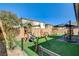 Backyard view featuring artificial turf, play area and privacy fence at 10064 Ocher Valley Ave, Las Vegas, NV 89178