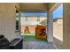 Covered patio with an outdoor kitchen, grill, playhouse, and artificial grass in the backyard at 10064 Ocher Valley Ave, Las Vegas, NV 89178