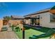 Spacious backyard featuring artificial turf, play area, and covered lounge seating at 10064 Ocher Valley Ave, Las Vegas, NV 89178