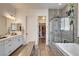 Elegant bathroom showcasing dual sinks, modern finishes, and a stylish tiled shower with glass door at 10064 Ocher Valley Ave, Las Vegas, NV 89178