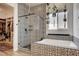 Patterned-tile bathroom featuring a walk-in shower, soaking tub, and access to a walk-in closet at 10064 Ocher Valley Ave, Las Vegas, NV 89178