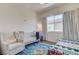 Comfortable bedroom with a crib, chair, and colorful rug, creating a cozy and inviting space at 10064 Ocher Valley Ave, Las Vegas, NV 89178