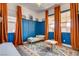 Charming bedroom with custom blue wainscoting, a colorful rug, and bright orange curtains at 10064 Ocher Valley Ave, Las Vegas, NV 89178
