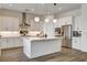 Well-lit kitchen featuring white cabinets, stainless steel appliances, a kitchen island, and hanging pendant lights at 10064 Ocher Valley Ave, Las Vegas, NV 89178