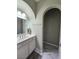 Bathroom vanity area with designer mirror, and marble-style tile flooring in alcove area at 10215 Radcliffe Peak Ave, Las Vegas, NV 89166