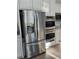 Stainless steel refrigerator and double ovens, integrated into the white kitchen cabinetry at 10215 Radcliffe Peak Ave, Las Vegas, NV 89166