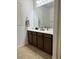 Bathroom featuring neutral countertops with dark wood cabinets and tile floors at 10220 Radcliffe Peak Ave, Las Vegas, NV 89166