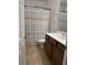Bathroom features dark wood cabinets, tile floors, and a shower with a tan and white striped shower curtain at 10220 Radcliffe Peak Ave, Las Vegas, NV 89166
