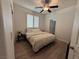 Bedroom features a large window, a ceiling fan, and wood-look floors, all in a neutral color palette at 10220 Radcliffe Peak Ave, Las Vegas, NV 89166