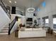Grand living room with high ceilings, stone fireplace, and a staircase with iron railings at 10220 Radcliffe Peak Ave, Las Vegas, NV 89166