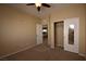 Light filled bedroom with neutral carpet, closet, open doorway, and standard ceiling fan at 10511 Loma Portal Ave, Las Vegas, NV 89166