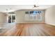 Bright, open living room featuring hardwood floors, a modern ceiling fan, and large windows for natural light at 1323 Winter Solstice Ave, Henderson, NV 89014