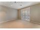 Bedroom featuring carpet, neutral paint, ceiling lighting, and shuttered doors to an outside terrace at 1405 San Juan Hills Dr # 104, Las Vegas, NV 89134
