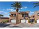 Inviting townhouse complex with a desert landscape and attached two-car garages at 1405 San Juan Hills Dr # 104, Las Vegas, NV 89134