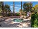 Community hot tub and lounge area surrounded by lush greenery and palm trees at 1405 San Juan Hills Dr # 104, Las Vegas, NV 89134