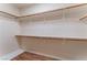 Large walk-in closet with built-in wooden shelving and clothes racks for optimal storage at 1405 San Juan Hills Dr # 104, Las Vegas, NV 89134