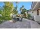 Backyard patio with outdoor seating, lush greenery, and a tranquil fountain at 174 Buena Ct, Henderson, NV 89074