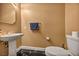 Powder bathroom with a white vanity sink, bronze fixtures, black marble floors, and tan walls at 174 Buena Ct, Henderson, NV 89074
