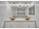 Elegant bathroom vanity with marble countertop, vessel sinks, gold fixtures, and decorative lighting at 174 Buena Ct, Henderson, NV 89074