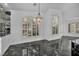 Dining area featuring shuttered windows, elegant lighting, and black marble flooring at 174 Buena Ct, Henderson, NV 89074