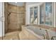 Luxurious bathroom featuring a soaking tub, walk-in shower, and natural light from the large bay window at 174 Buena Ct, Henderson, NV 89074