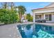 Beautiful pool with lush landscaping, outdoor kitchen, and comfortable patio furniture at 174 Buena Ct, Henderson, NV 89074