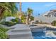 Relaxing backyard oasis with a pool, waterfall feature, lush landscaping, and comfortable seating at 174 Buena Ct, Henderson, NV 89074