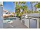 Outdoor kitchen by the pool, including stainless steel grill, sink and beverage cooler at 174 Buena Ct, Henderson, NV 89074